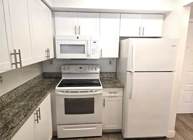 a kitchen with a stove a refrigerator and a sink