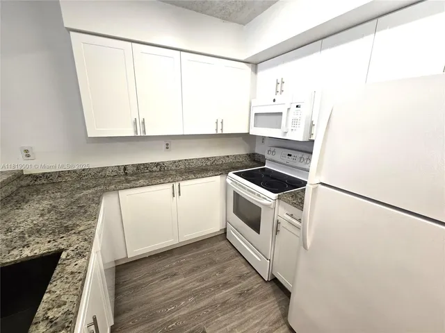 a kitchen with a white cabinets and white appliances