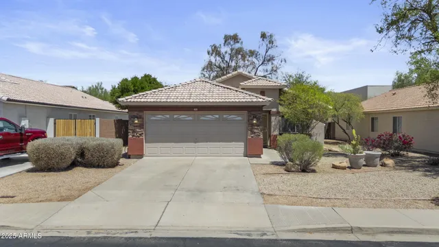 a front view of a house with a yard and potted plants