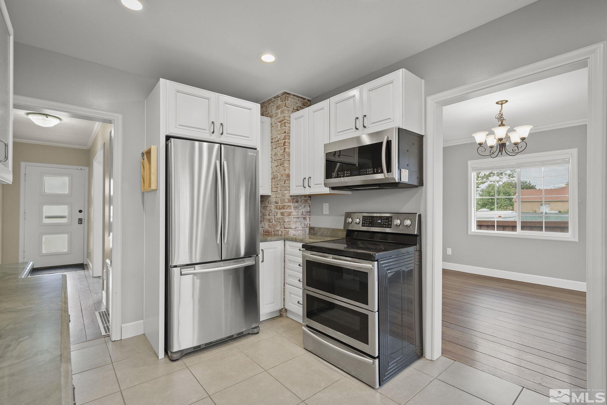 701 Stewart Street Reno, NV 89502 - Photo 11 of 40 a kitchen with granite countertop a refrigerator and a stove top oven