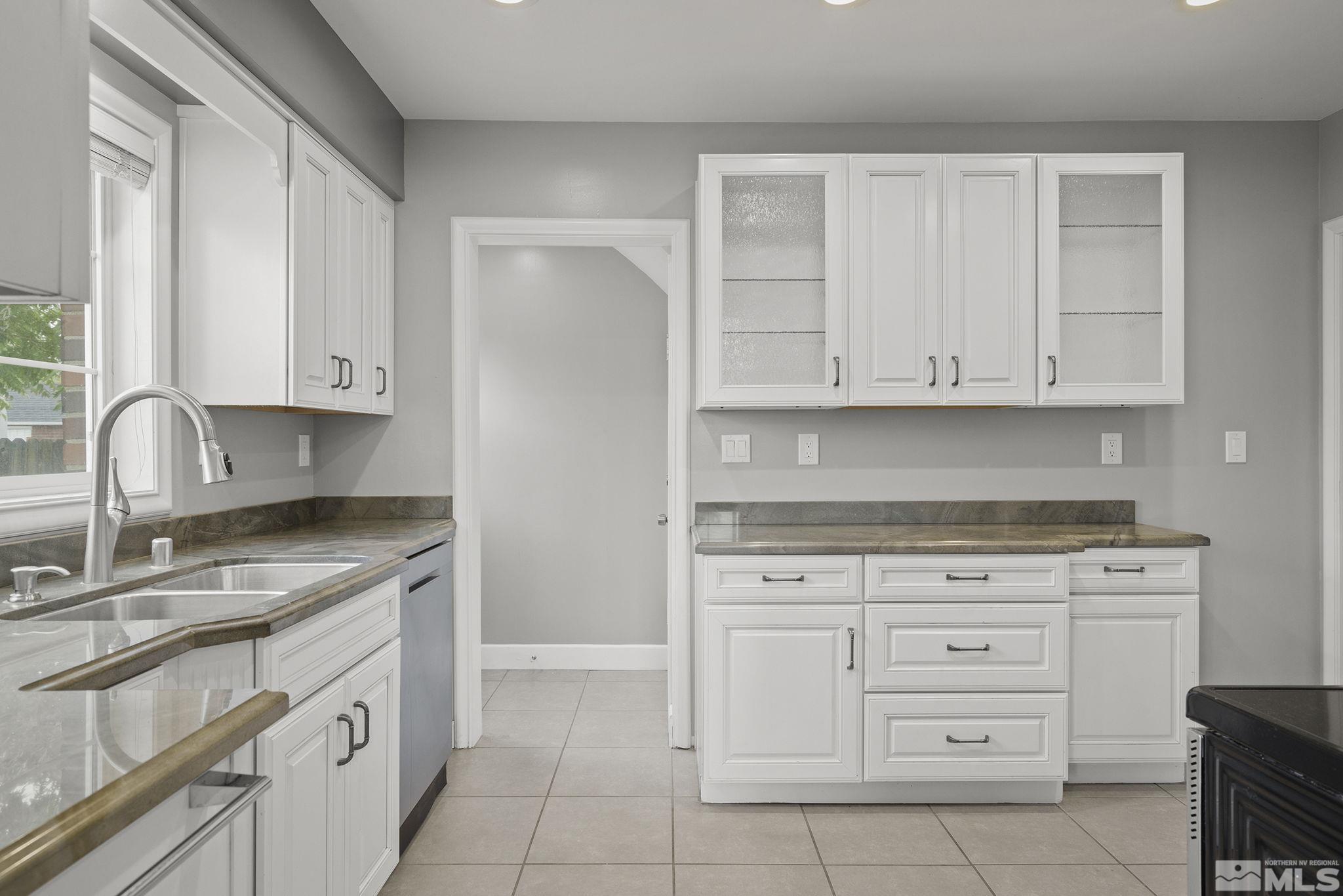 701 Stewart Street Reno, NV 89502 - Photo 12 of 40 a kitchen with granite countertop white cabinets and sink