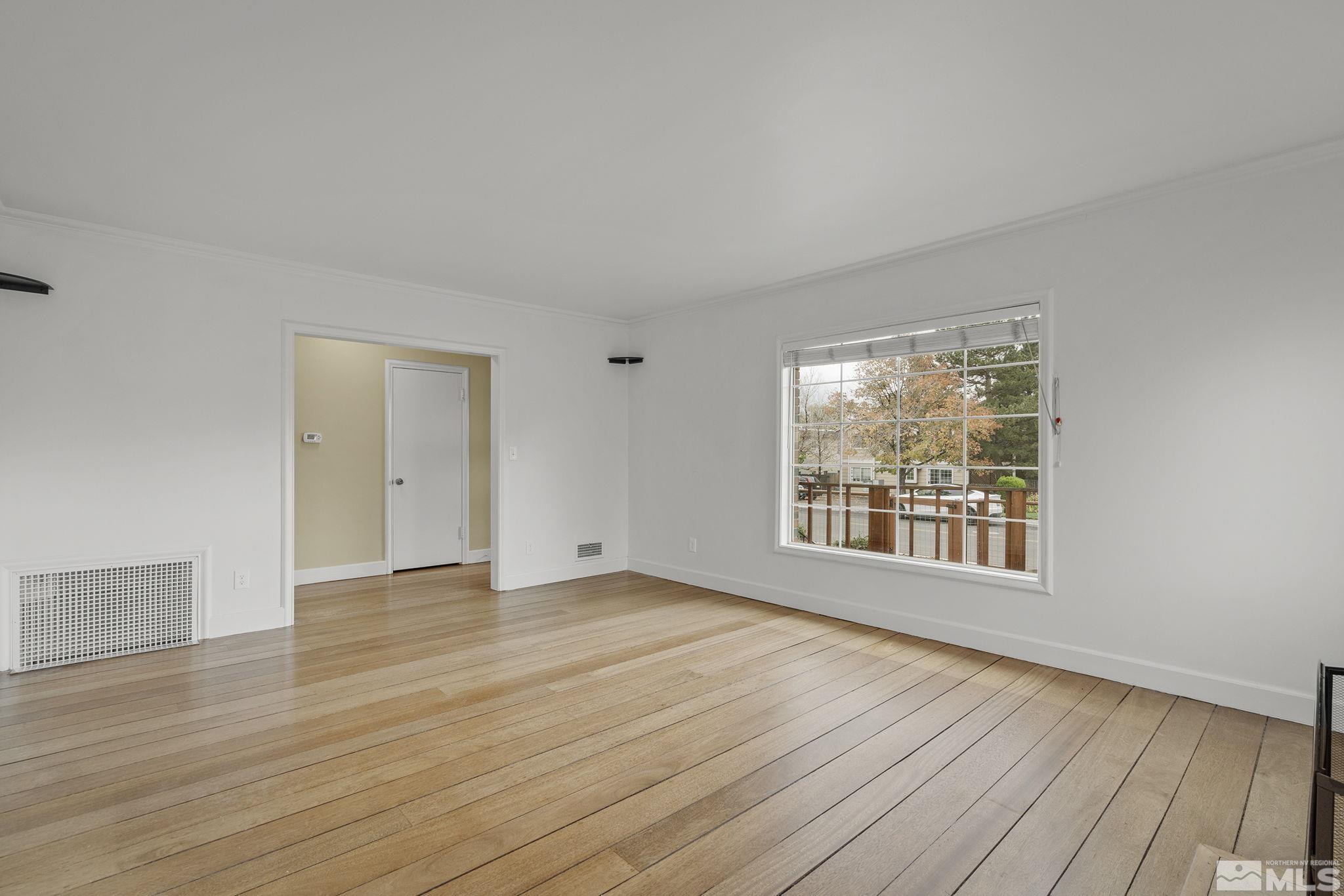 701 Stewart Street Reno, NV 89502 - Photo 6 of 40 a view of an empty room with wooden floor and a window