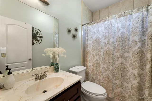 a bathroom with a sink a toilet and a mirror