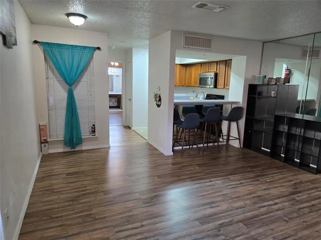 a kitchen with stainless steel appliances a dining table and chairs in it