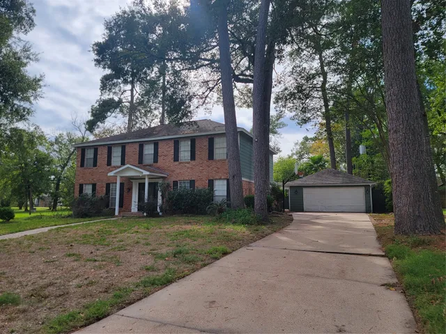 front view of a house with a yard and an trees