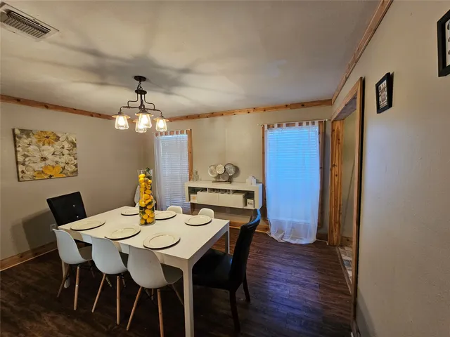 a view of a dining room with furniture a chandelier and wooden floor