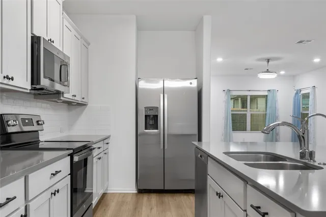 a kitchen with kitchen island a white cabinets and refrigerator