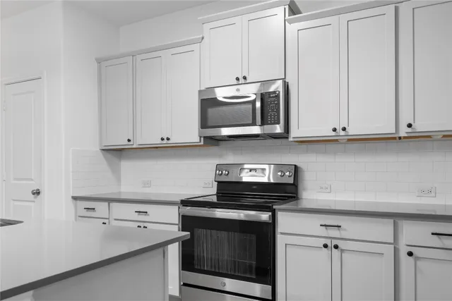 a kitchen with stainless steel appliances granite countertop a sink a stove and a refrigerator