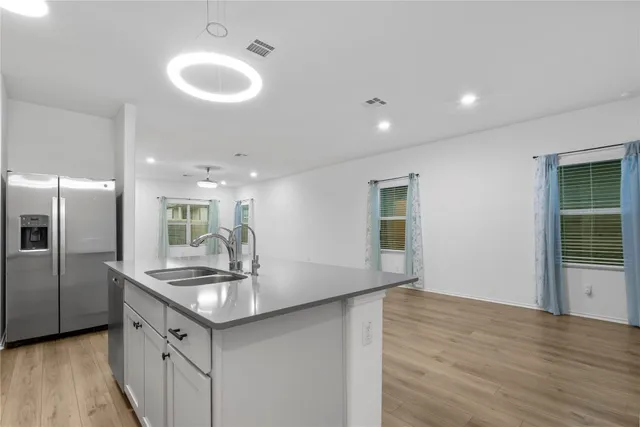 a kitchen with stainless steel appliances granite countertop white cabinets and a stove