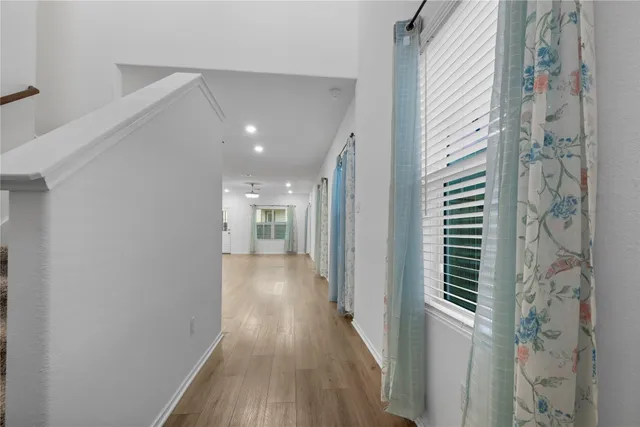 a view of a hallway with wooden floor and staircase