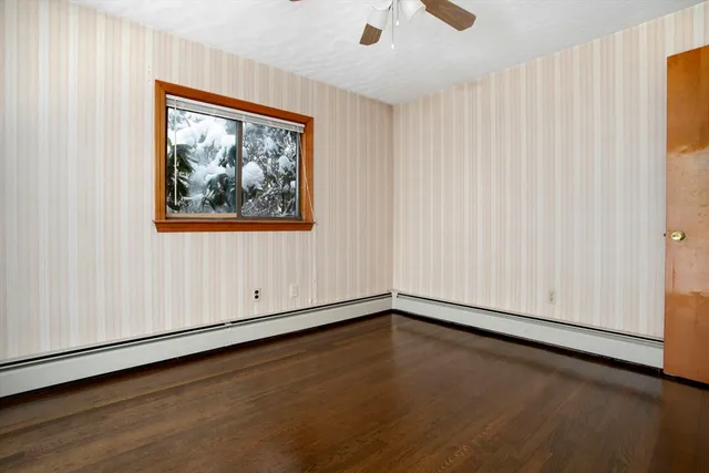a view of an empty room with wooden floor