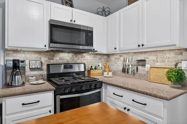a kitchen with granite countertop a sink window and cabinets
