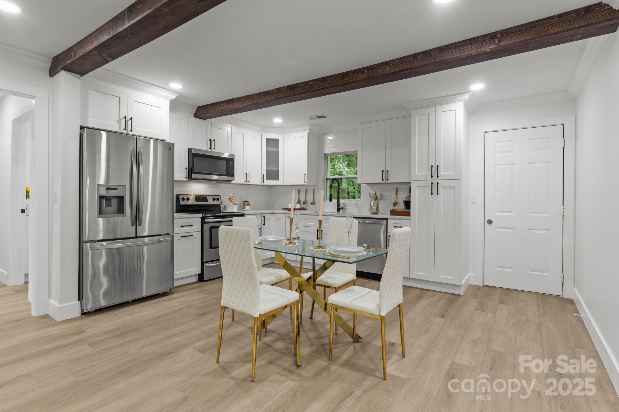 809 Miller Street Gastonia, NC 28052 - Photo 6 of 19 a kitchen with stainless steel appliances a refrigerator a stove a dining table and chairs