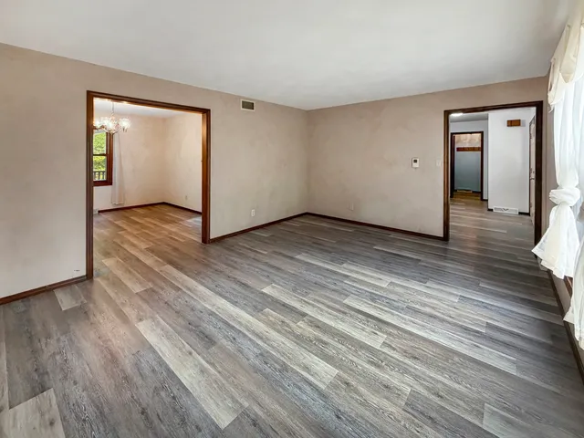 a view of a room with wooden floor and window