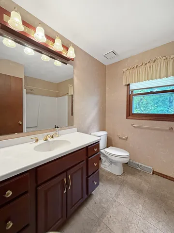 a bathroom with a toilet sink and mirror