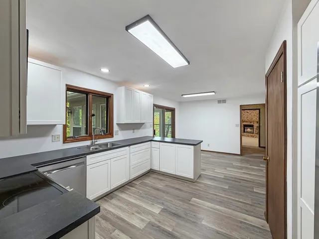 a large white kitchen with sink and cabinets