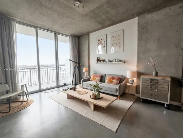 a living room with furniture and large windows