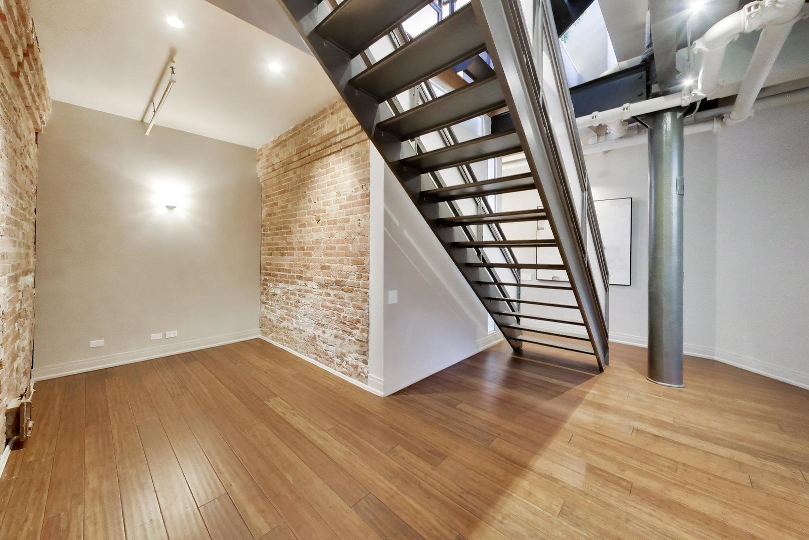 1000 West Washington Boulevard, Unit 145 Chicago, IL 60607 - Photo 24 of 45 wooden floor in an empty room with a fireplace