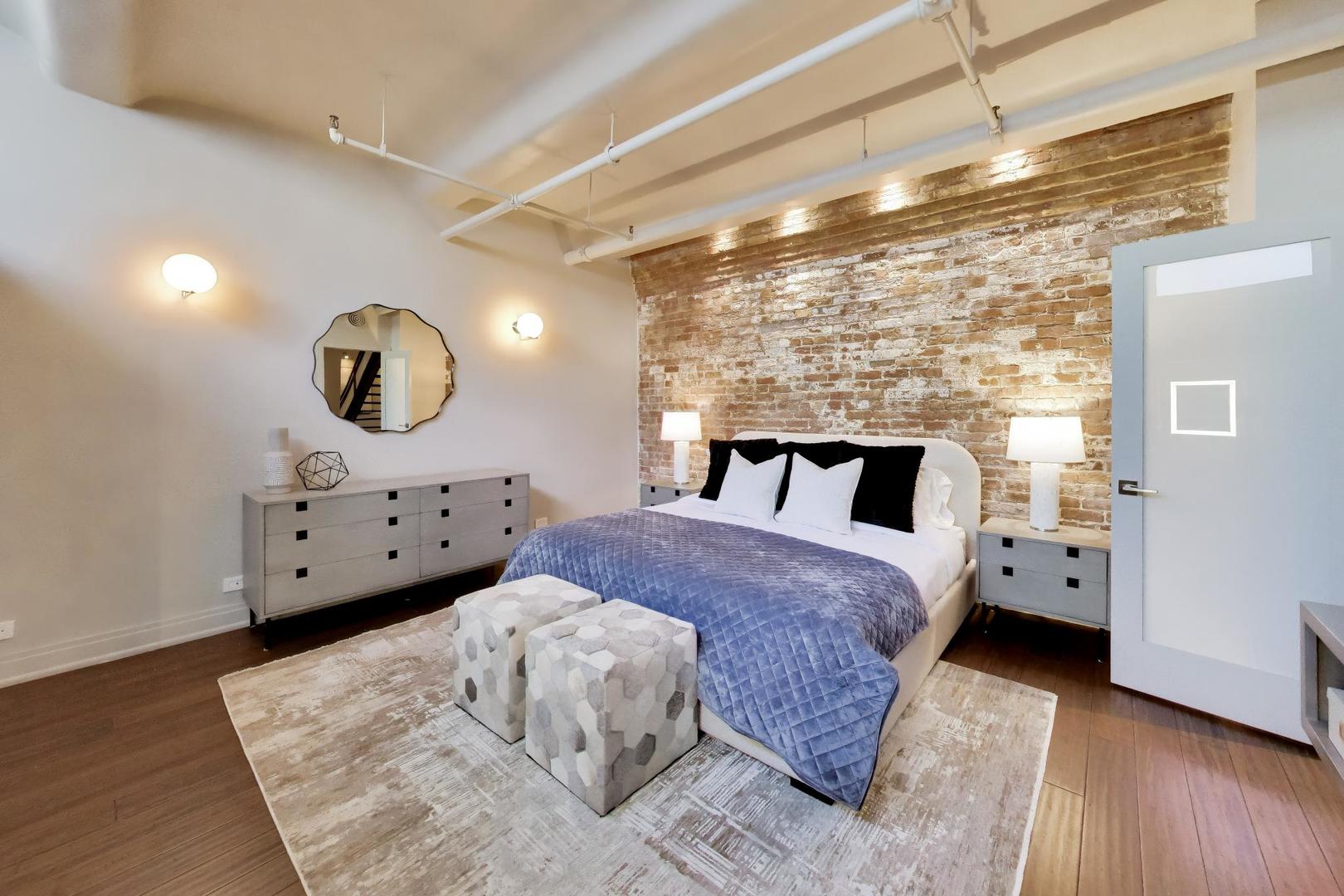 1000 West Washington Boulevard, Unit 145 Chicago, IL 60607 - Photo 27 of 45 a spacious bedroom with a bed and wooden floor