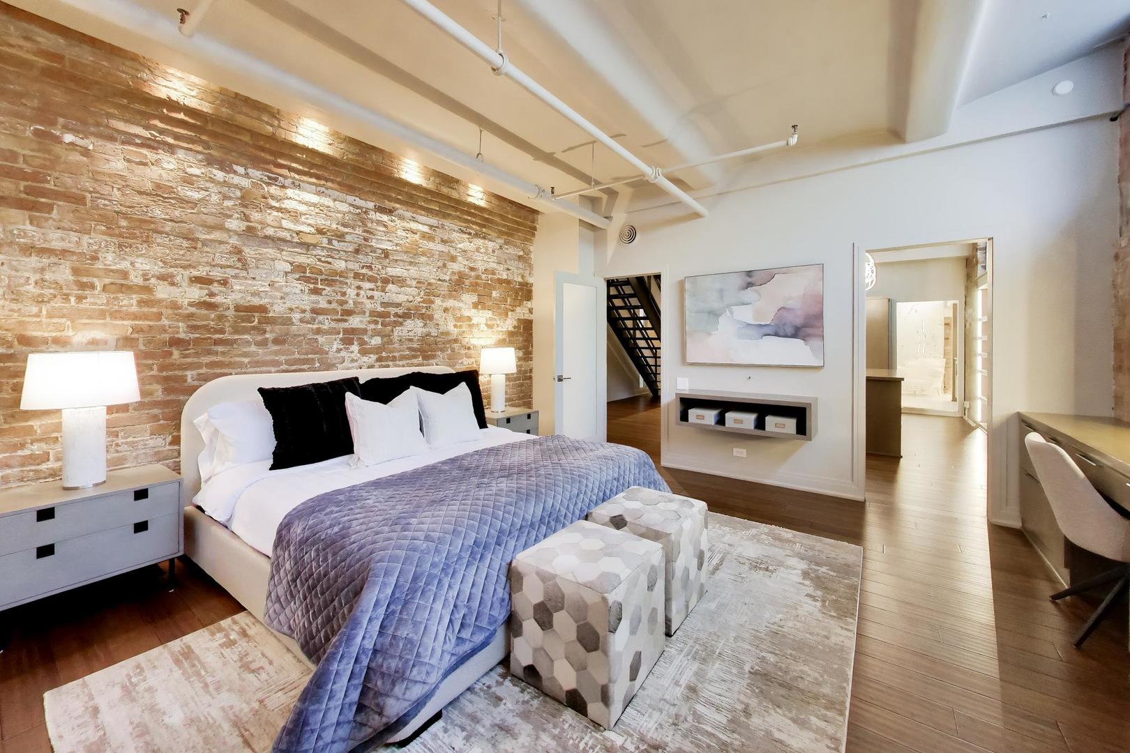 1000 West Washington Boulevard, Unit 145 Chicago, IL 60607 - Photo 28 of 45 a spacious bedroom with a bed and wooden floor