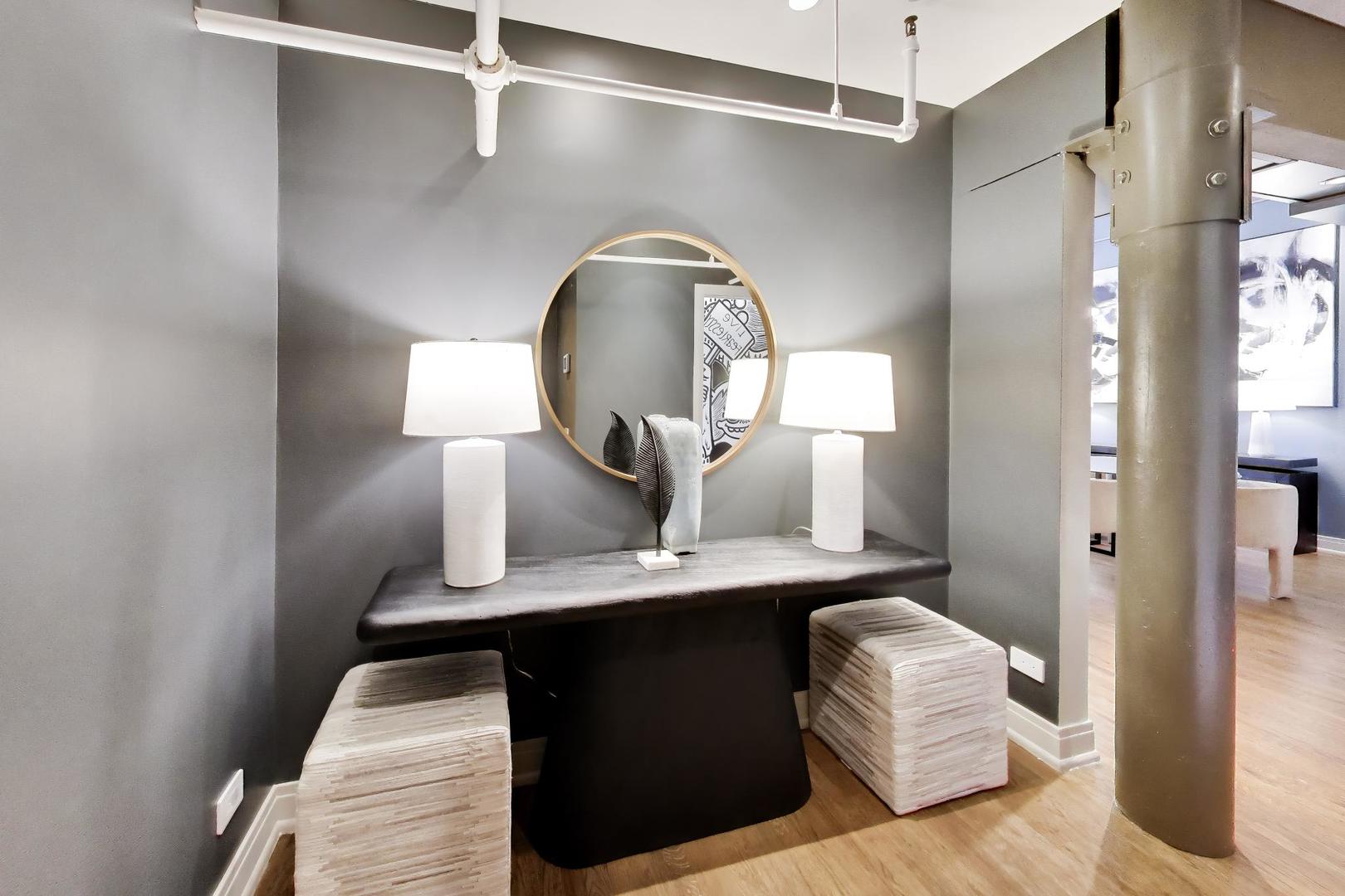 1000 West Washington Boulevard, Unit 145 Chicago, IL 60607 - Photo 3 of 45 a living room with a bed and a mirror