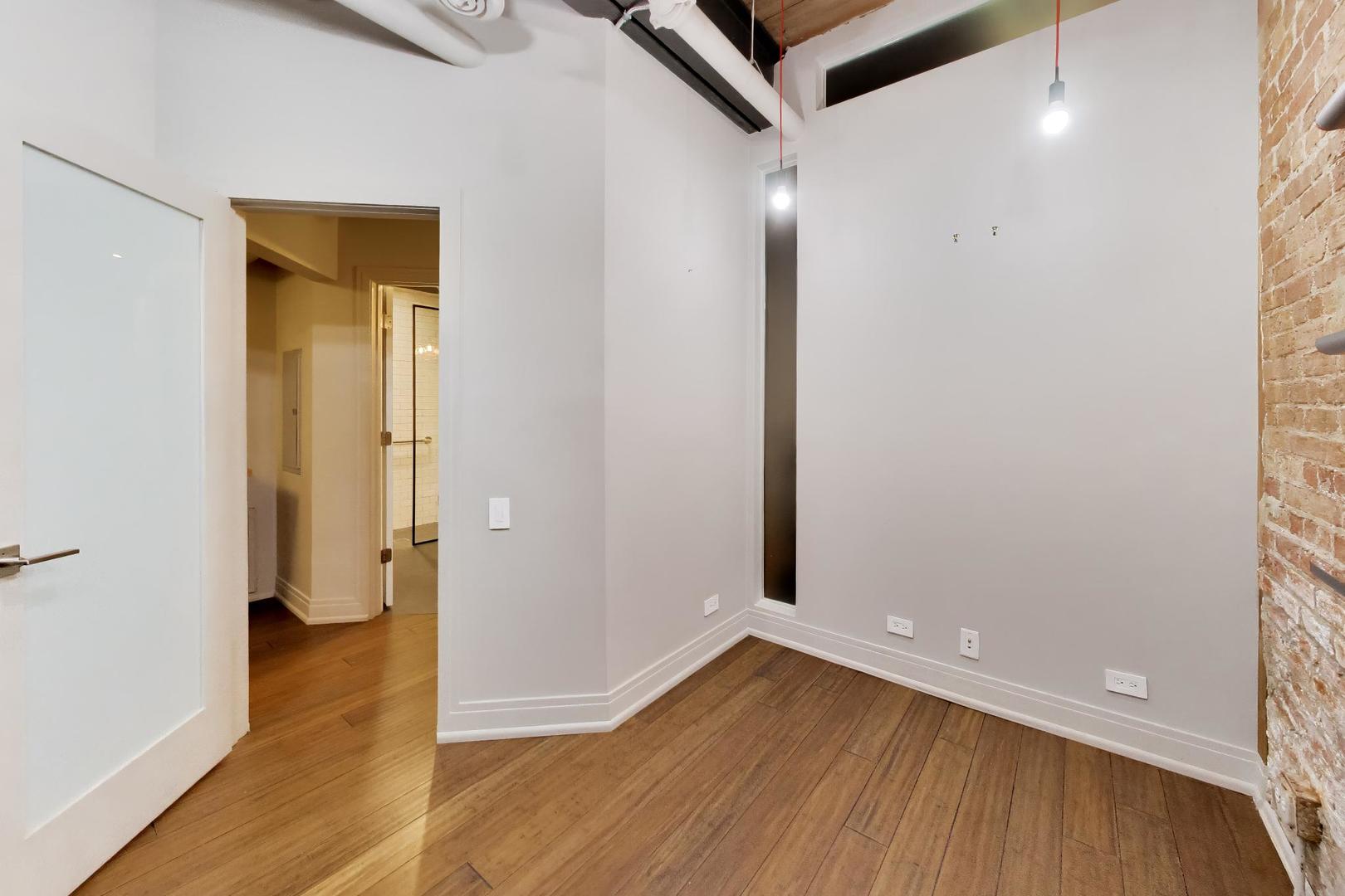 1000 West Washington Boulevard, Unit 145 Chicago, IL 60607 - Photo 36 of 45 a view of a hallway with wooden floor and a bathroom