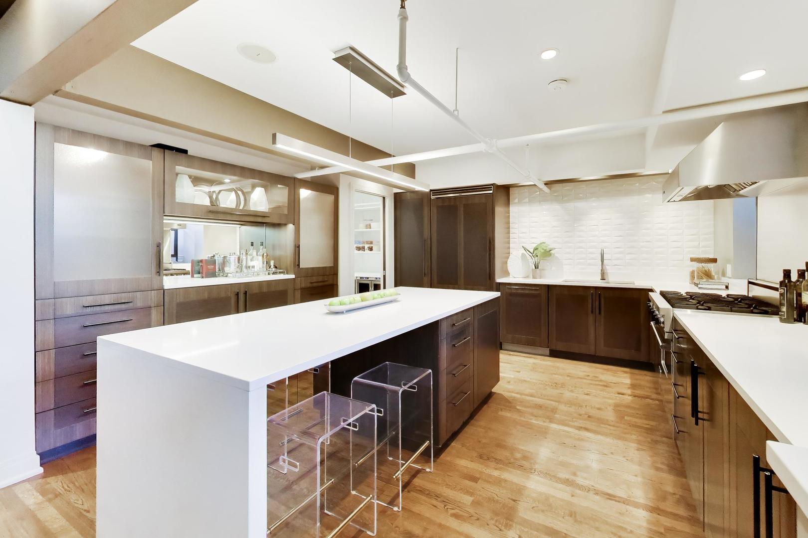 1000 West Washington Boulevard, Unit 145 Chicago, IL 60607 - Photo 10 of 45 a large kitchen with kitchen island a sink a counter space and stainless steel appliances