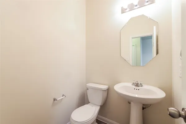 a bathroom with a toilet a sink and mirror