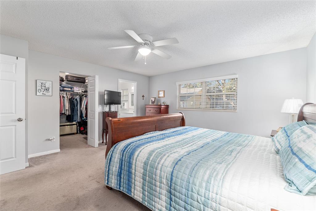8889 Southwest 96th Street, Unit E Ocala, FL 34481 - Photo 22 of 40 a bedroom with a large bed and a chandelier