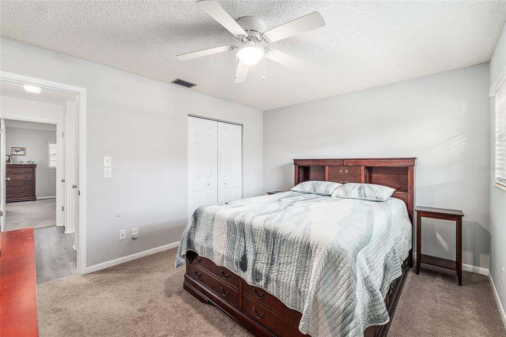 8889 Southwest 96th Street, Unit E Ocala, FL 34481 - Photo 27 of 40 a bedroom with a bed and a chandelier