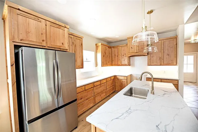 a kitchen with granite countertop a refrigerator and a sink