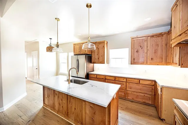 a kitchen with stainless steel appliances granite countertop a sink and a wooden floor