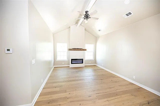 a view of an empty room with a window and a ceiling fan