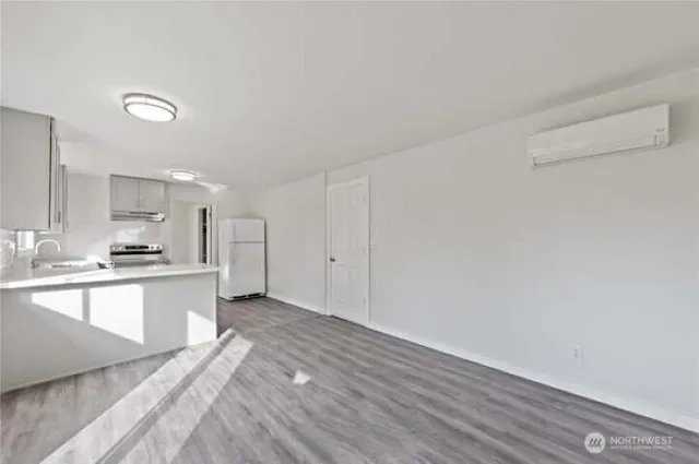 a large white kitchen with a sink and dishwasher a stove with wooden floor