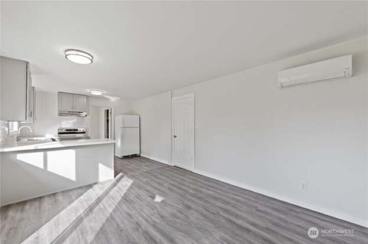 10601 55th Avenue South Seattle, WA 98178 - Photo 11 of 26 a large white kitchen with a sink and dishwasher a stove with wooden floor