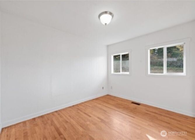 10601 55th Avenue South Seattle, WA 98178 - Photo 17 of 26 a view of empty room with wooden floor and fan