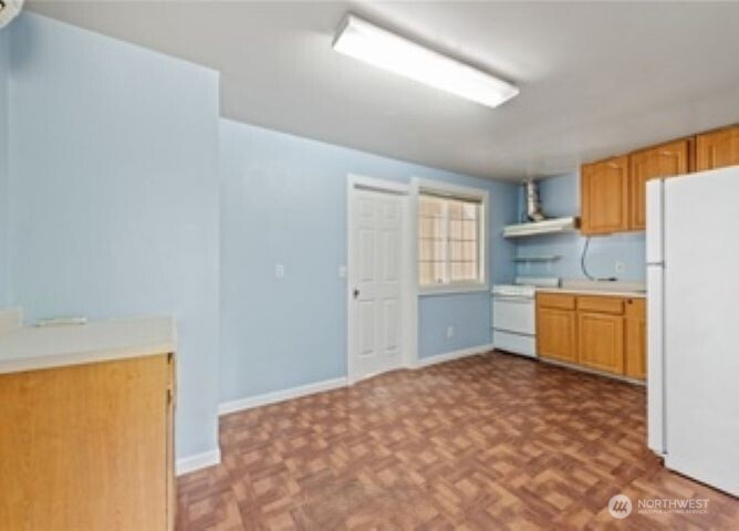 10601 55th Avenue South Seattle, WA 98178 - Photo 22 of 26 a kitchen with a refrigerator sink cabinets and a window