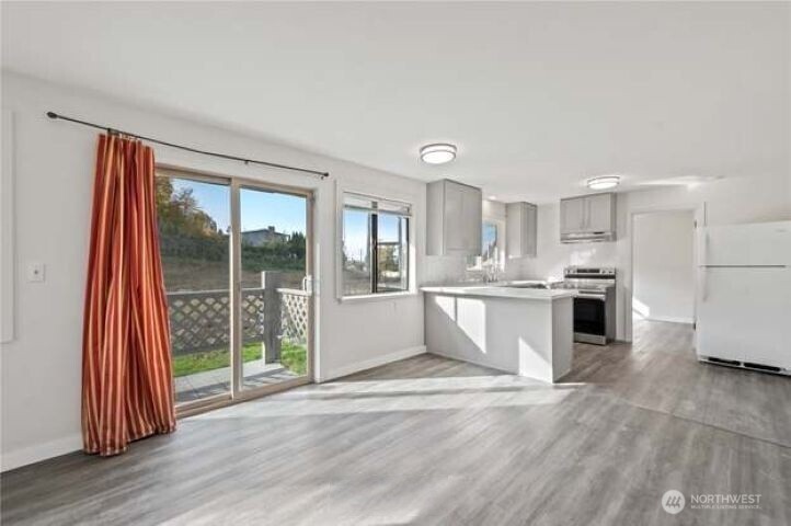 10601 55th Avenue South Seattle, WA 98178 - Photo 8 of 26 a large white kitchen with stainless steel appliances granite countertop a refrigerator oven a s sink and a large window