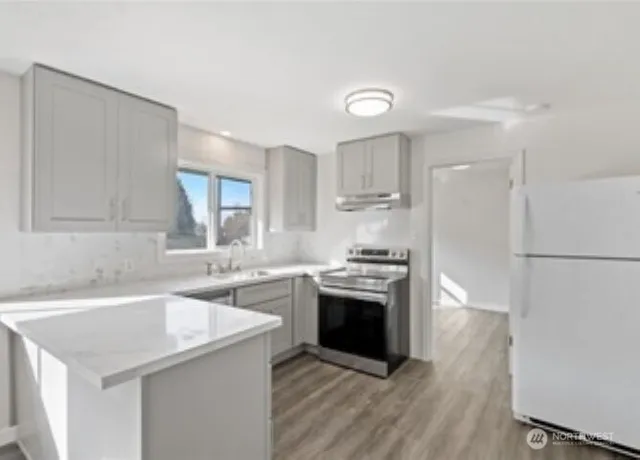 a kitchen with stainless steel appliances granite countertop a sink stove and refrigerator