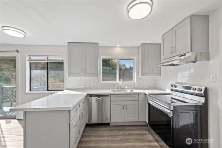 10601 55th Avenue South Seattle, WA 98178 - Photo 10 of 26 a kitchen with a sink stove and cabinets