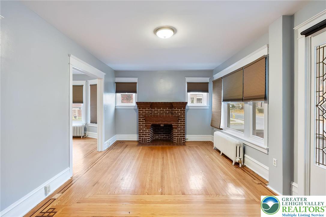 1150 North 19th Street, Unit 1 Allentown, PA 18104 - Photo 14 of 32 a view of a livingroom with a fireplace a ceiling fan and wooden floor