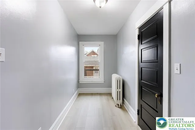 a view of hallway with stairs and a window