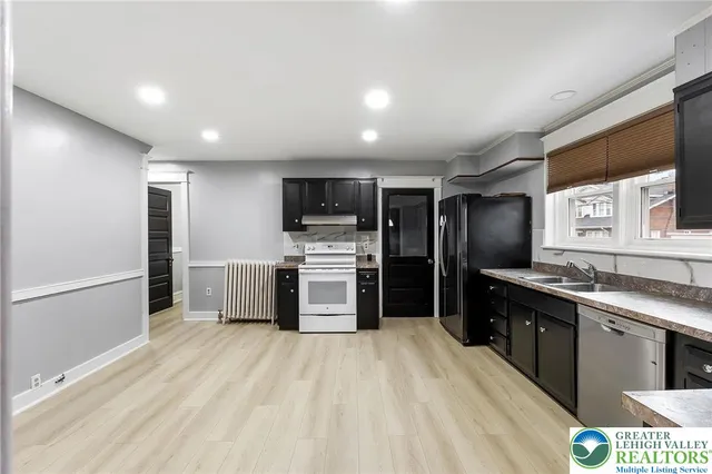 a kitchen with stainless steel appliances a refrigerator a sink a stove top oven a sink and dishwasher