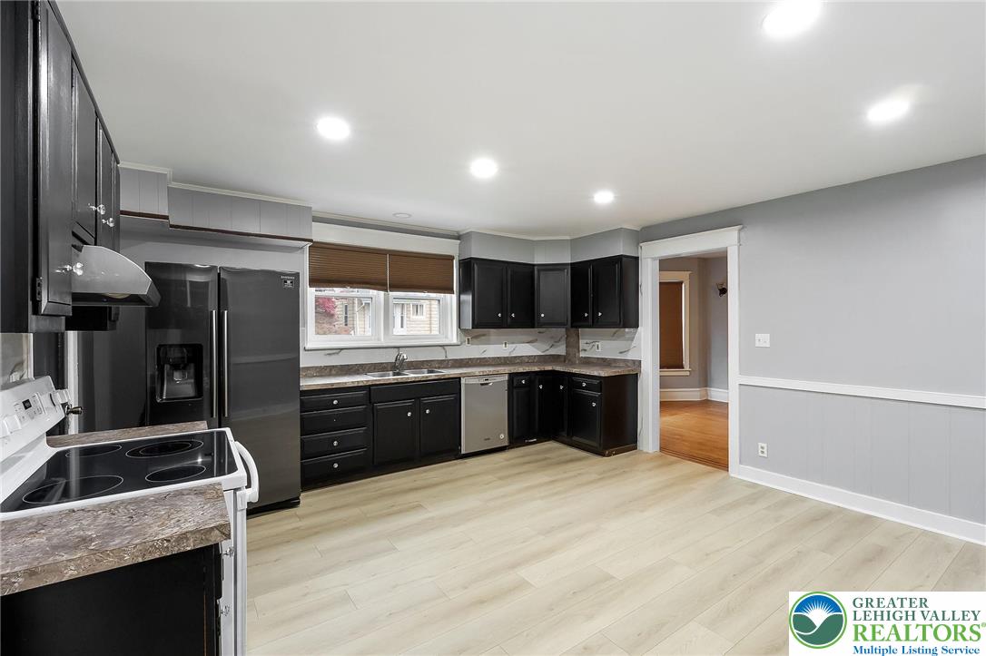 1150 North 19th Street, Unit 1 Allentown, PA 18104 - Photo 8 of 32 a kitchen with stainless steel appliances kitchen island granite countertop a refrigerator a sink a stove a oven a dining table and chairs