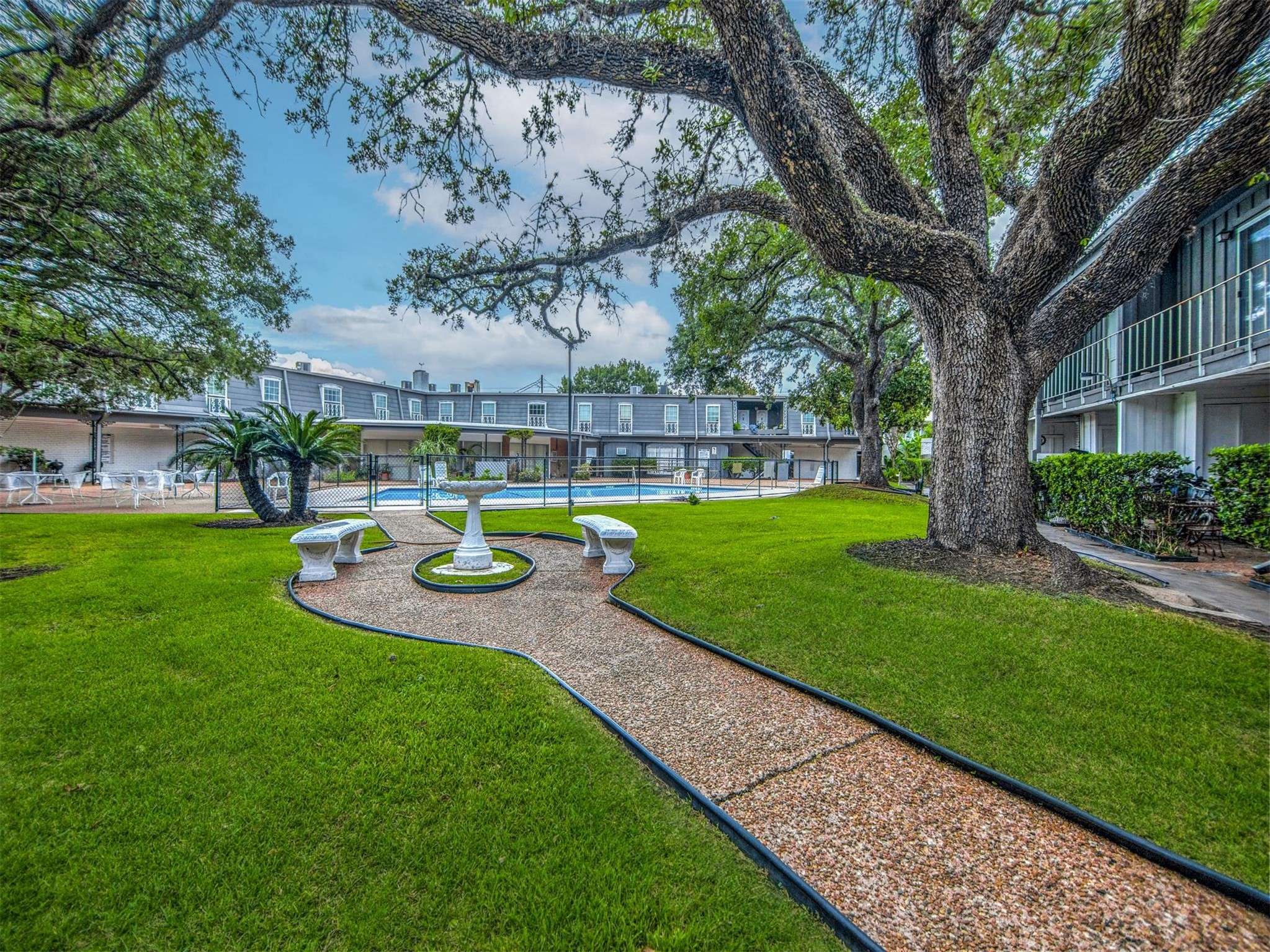 7841 Rue St Cyr Street, Unit 45 Houston, TX 77074 - Photo 7 of 7 a view of a swimming pool with a garden and plants