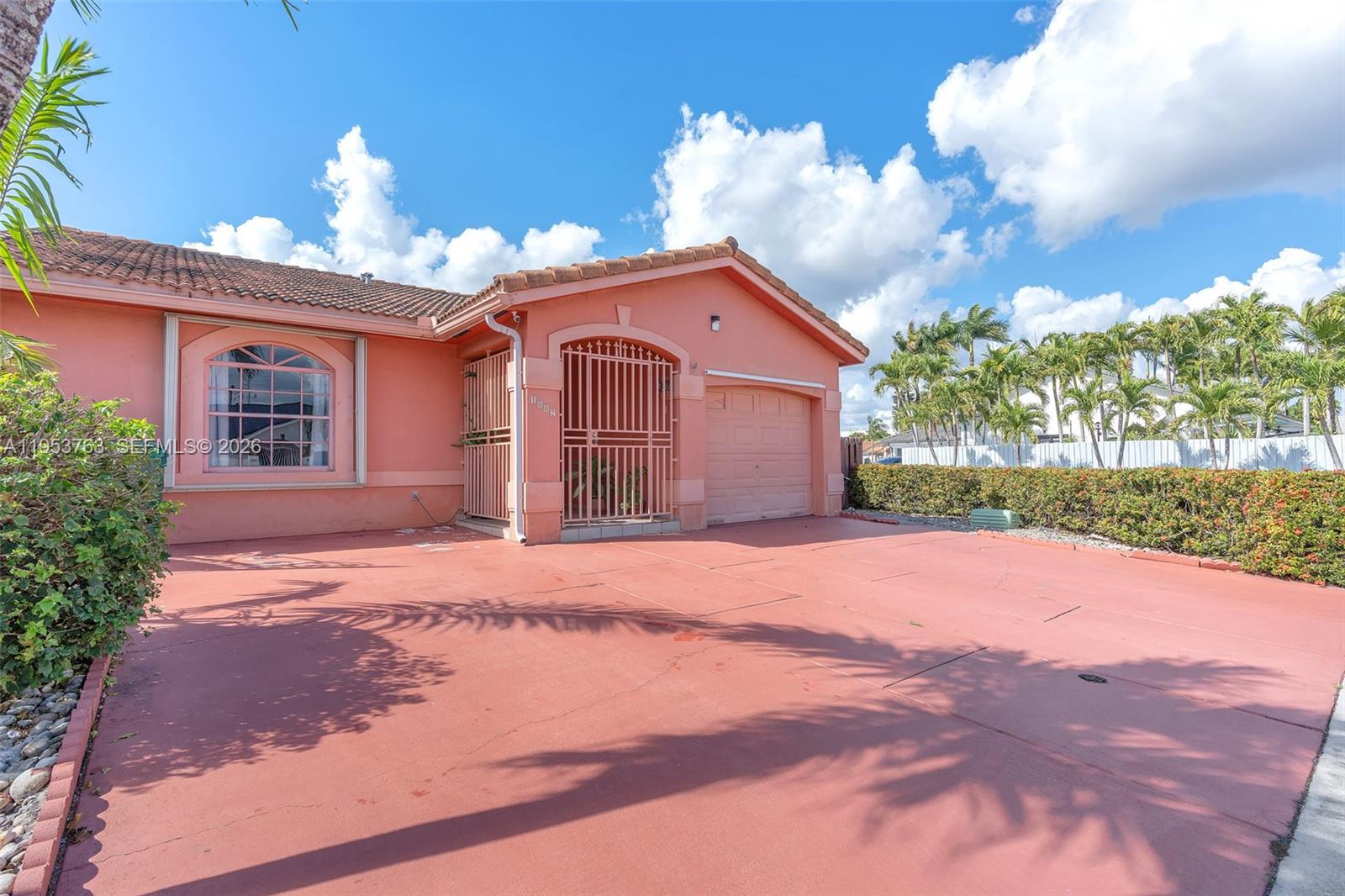 1002 Southwest 142nd Court Miami, FL 33184 - Photo 3 of 50 a front view of a house with a yard and garage