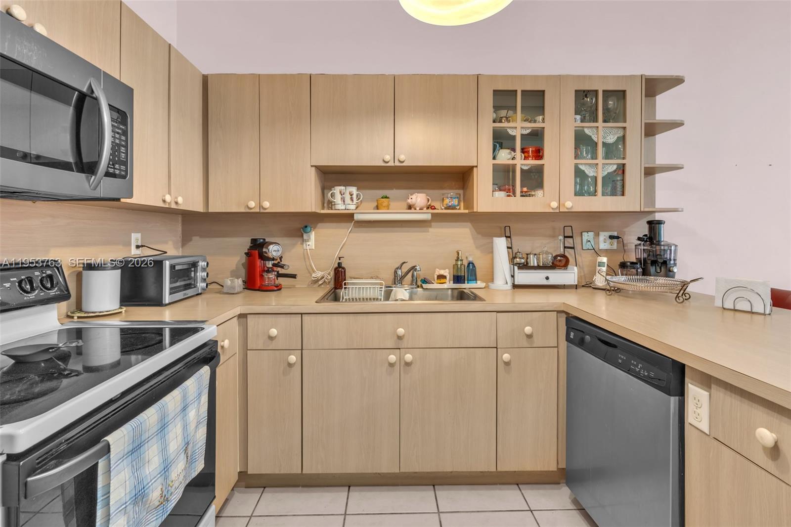 1002 Southwest 142nd Court Miami, FL 33184 - Photo 8 of 50 a kitchen with cabinets appliances a sink and a counter top space