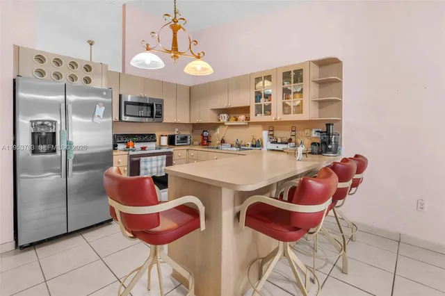 a kitchen with stainless steel appliances granite countertop a sink and a refrigerator