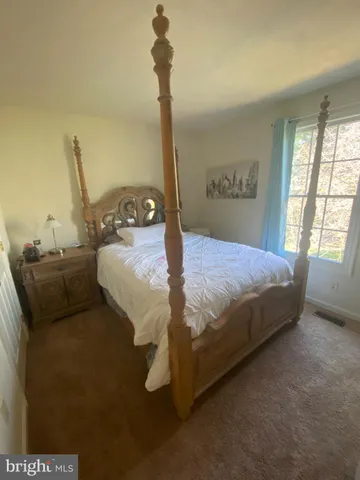 a bed sitting in a bedroom next to a window