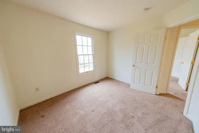 an empty room with windows and bathroom view